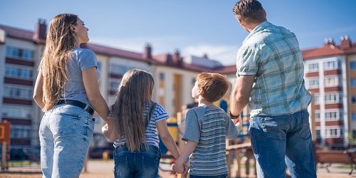 family standing in front of apartments