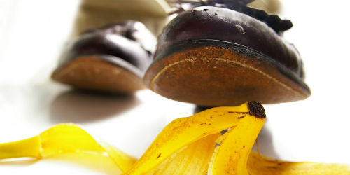 Shoe poised to step on yellow banana peel