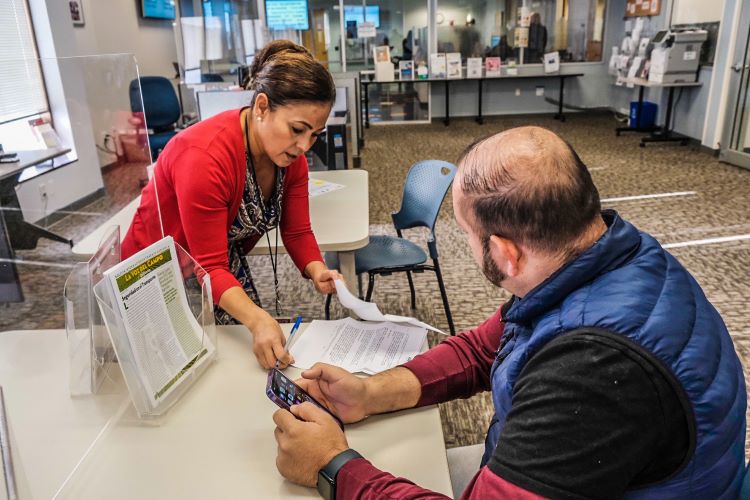 Worker helping man fill out a form