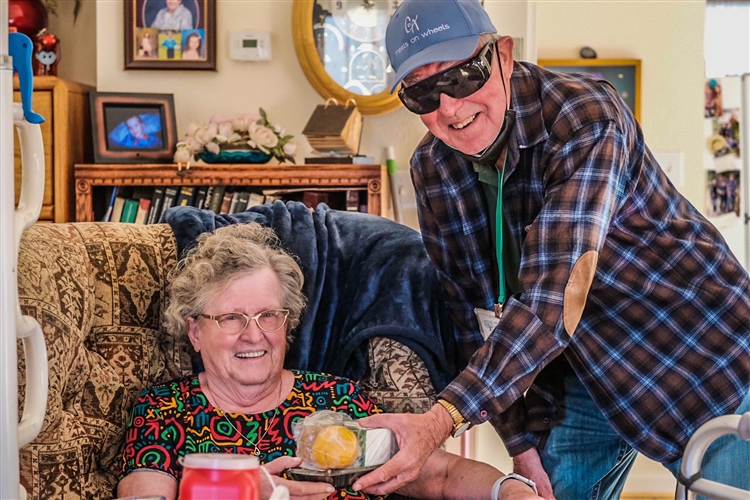 Older woman receiving a meals on wheels delivery